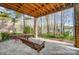 This beautiful backyard features a covered patio and swing overlooking the serene lake at 928 Thorn Ridge Ln, Clover, SC 29710
