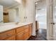 Well-lit bathroom features a wooden vanity, sink, large mirror, and tile floors at 928 Thorn Ridge Ln, Clover, SC 29710