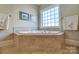 Bathroom features a tiled corner bathtub with a bright window for natural light at 928 Thorn Ridge Ln, Clover, SC 29710