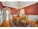 Elegant dining room with wood floors, chandelier, and stylish red accent wall with white trim at 928 Thorn Ridge Ln, Clover, SC 29710