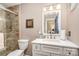Cozy bathroom with a tiled shower, toilet, vanity, and mirror at 9401 Elvis Dr, Charlotte, NC 28215