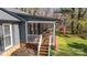 Home's inviting covered porch with classic rocking chairs and an American flag at 9401 Elvis Dr, Charlotte, NC 28215