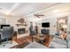 Cozy living room featuring a brick fireplace, ceiling fan, comfortable seating, and natural light at 9401 Elvis Dr, Charlotte, NC 28215