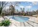 Backyard pool with lounge chairs, a barbecue grill, and mature trees for privacy at 9401 Elvis Dr, Charlotte, NC 28215