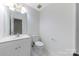 Clean bathroom with white vanity, toilet, mirror and tile flooring at 9423 Fairmead Dr, Charlotte, NC 28269