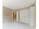 Bedroom with wall to wall carpet features a closet and an open door to a hallway at 9423 Fairmead Dr, Charlotte, NC 28269