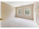 Bedroom with neutral walls and carpet features two windows and a closet shelf at 9423 Fairmead Dr, Charlotte, NC 28269