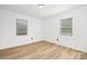 Inviting bedroom with two bright windows showcasing natural light and modern wood-look flooring for warm ambiance at 9930 Sardis Oaks Rd, Charlotte, NC 28270