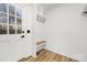 Functional mudroom entry featuring coat hooks, built-in bench, and bright, neutral walls for organized storage at 9930 Sardis Oaks Rd, Charlotte, NC 28270