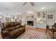 Open living room with a brick fireplace, built-in shelving, and a view into the kitchen at 101 Woodvale Cir, Lincolnton, NC 28092