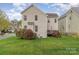 A view of the house from the back yard, surrounded by green grass, and bushes at 10802 Tradition View Dr, Charlotte, NC 28269