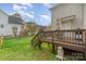 A backyard featuring a small wood deck with a wooden staircase going to the grassy yard at 10802 Tradition View Dr, Charlotte, NC 28269