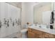 A well-lit bathroom with a toilet, sink, and shower with a floral shower curtain at 10802 Tradition View Dr, Charlotte, NC 28269
