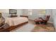 Comfortable bedroom with hardwood floors, natural light from windows, and a relaxing chair at 10802 Tradition View Dr, Charlotte, NC 28269