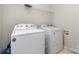 Functional laundry room with a washing machine and dryer and shelving at 10802 Tradition View Dr, Charlotte, NC 28269