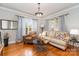 Bright living room with hardwood floors, a cozy sofa, and an adjacent chair at 10802 Tradition View Dr, Charlotte, NC 28269