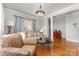 Inviting living room featuring hardwood floors, neutral walls, and a stylish patterned sofa at 10802 Tradition View Dr, Charlotte, NC 28269