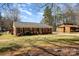 A well-maintained brick home with classic design, complemented by a lush green lawn and a quaint detached structure at 11018 Despa Dr, Mint Hill, NC 28227