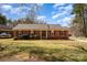 Charming single-story brick home with manicured lawn and mature trees, bathed in the warm glow of daylight at 11018 Despa Dr, Mint Hill, NC 28227