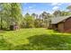 Expansive backyard with lush greenery, mature trees, and a charming shed, offering a serene outdoor space at 123 Lucy Ln, Statesville, NC 28625