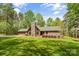 Charming stone and wood home with a stone chimney, green roof, and lush lawn at 123 Lucy Ln, Statesville, NC 28625