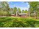 Charming stone and wood home with a stone chimney, green roof, and lush lawn at 123 Lucy Ln, Statesville, NC 28625