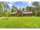 Beautiful backyard features a lush lawn, mature trees, and landscaping for a serene and private retreat at 123 Lucy Ln, Statesville, NC 28625