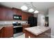 Well-lit kitchen features stainless steel appliances, countertops, cabinets, and an island at 12915 Settlers Trail Ct, Charlotte, NC 28278