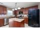 Well-equipped kitchen with stainless steel appliances, dark wood cabinets, and a kitchen island at 12915 Settlers Trail Ct, Charlotte, NC 28278