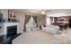 Inviting living room with a fireplace, large windows, and an open layout to the kitchen at 12915 Settlers Trail Ct, Charlotte, NC 28278