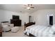 Bright main bedroom featuring a ceiling fan, a dresser with TV, and a cozy armchair at 12915 Settlers Trail Ct, Charlotte, NC 28278