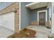 Home's front entrance with a dark brown door, brick accents, and gray siding at 1305 31St Ne St, Conover, NC 28613