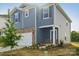 Two-story home with blue siding, brick accents, a two-car garage, and a covered front porch at 1305 31St Ne St, Conover, NC 28613