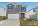 Two-story home with blue siding, brick accents, a white two-car garage door, and lush landscaping at 1305 31St Ne St, Conover, NC 28613