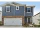 Close-up shot of a two-story home with blue siding, brick accents, and a two-car garage at 1305 31St Ne St, Conover, NC 28613