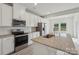 Contemporary kitchen showcasing granite counters, stainless appliances, and white cabinetry with a view to the backyard at 1305 31St Ne St, Conover, NC 28613