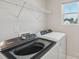 Bright laundry room with modern Whirlpool washer and dryer, wire shelf and a window at 1305 31St Ne St, Conover, NC 28613