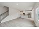 Spacious open-concept living area with sleek wood-look flooring, a staircase, and a modern kitchen with stainless appliances at 1305 31St Ne St, Conover, NC 28613