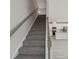 Staircase leading to a bright, open kitchen with white cabinetry and stainless steel appliances at 1305 31St Ne St, Conover, NC 28613