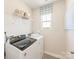 Functional laundry room equipped with modern washer and dryer, complemented by shelving for organization and storage at 1329 31St Ne St, Conover, NC 28613
