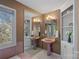 Retro bathroom with pink pedestal sinks, vintage lighting, and built-in shelving for storage at 1624 Chadmore Nw Ln, Concord, NC 28027