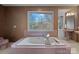 Retro bathroom featuring a pink tiled tub surround, a jetted tub, and a large window at 1624 Chadmore Nw Ln, Concord, NC 28027