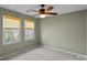 Serene bedroom featuring neutral carpet, two bright windows, and a ceiling fan for comfort at 1624 Chadmore Nw Ln, Concord, NC 28027