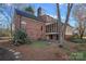 Rear exterior view of brick home with screened porch, deck and manicured backyard with mature trees and landscaping at 1624 Chadmore Nw Ln, Concord, NC 28027
