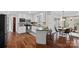 Modern kitchen featuring white cabinetry, stainless steel appliances, a breakfast bar, and hardwood floors at 1624 Chadmore Nw Ln, Concord, NC 28027