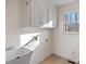 Bright laundry room features ample cabinet space, a utility sink, and a window for natural light at 1624 Chadmore Nw Ln, Concord, NC 28027