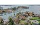 Aerial view showcases waterfront homes, lush trees, and a marina with many boat slips at 16624 Flying Jib Rd, Cornelius, NC 28031