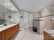 Elegant bathroom featuring a double vanity, a walk-in shower, and neutral tiling at 16624 Flying Jib Rd, Cornelius, NC 28031