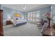 Cozy bedroom featuring a comfortable bed, blue walls, and a large window with plantation shutters at 16624 Flying Jib Rd, Cornelius, NC 28031