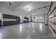 Expansive three-car garage with epoxy flooring, custom storage cabinets, and ample workspace at 16624 Flying Jib Rd, Cornelius, NC 28031